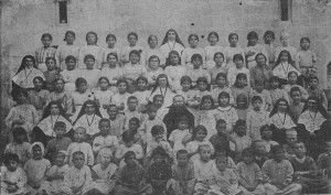 صبيان وبنات الميتم في أورفا، في العام 1919،يحوطون الأب جْواشان دوليون وراهبات لونس لوسونييه(Le Petit Messager, N° 269, février 1920, p. 38)
